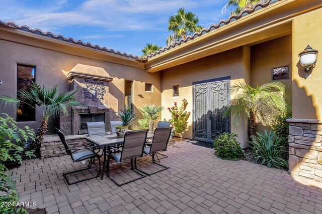 view of patio featuring an outdoor stone fireplace and outdoor dining space