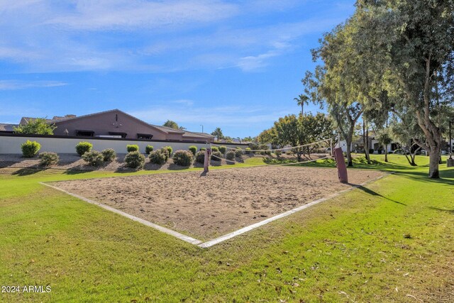 surrounding community with volleyball court and a lawn