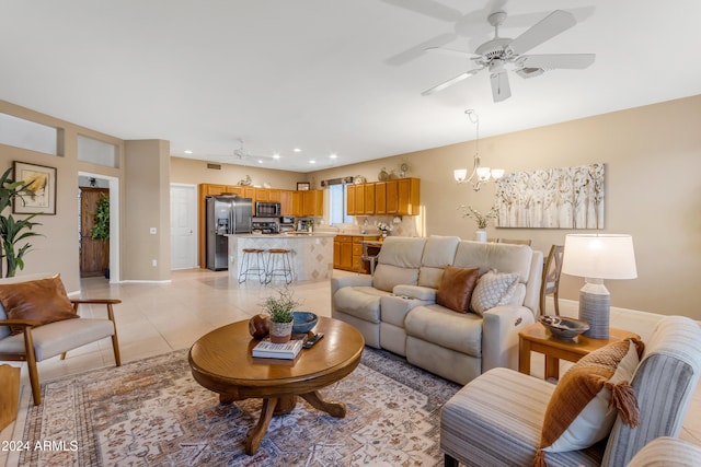 living room with ceiling fan with notable chandelier and light tile patterned floors