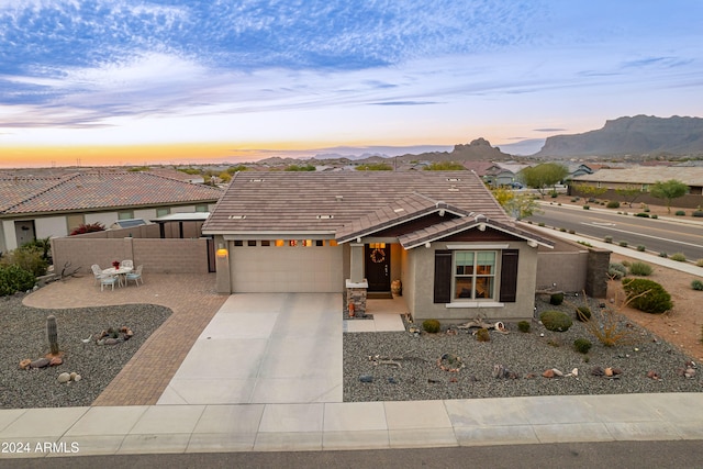 view of front of house featuring a mountain view, a garage, and a patio