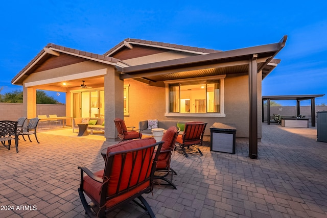 view of patio featuring ceiling fan, an outdoor living space, and a hot tub