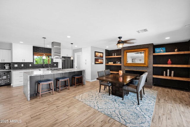 8730 E Montecito Ave, Scottsdale, AZ 85251 - dining area with beverage cooler, light wood-style flooring, a ceiling fan, baseboards, and recessed lighting