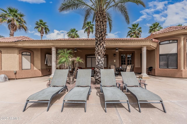 23644 N 67th Ave, Peoria, AZ 85383 - rear view of house featuring outdoor dining space, a tile roof, stucco siding, a ceiling fan, and a patio