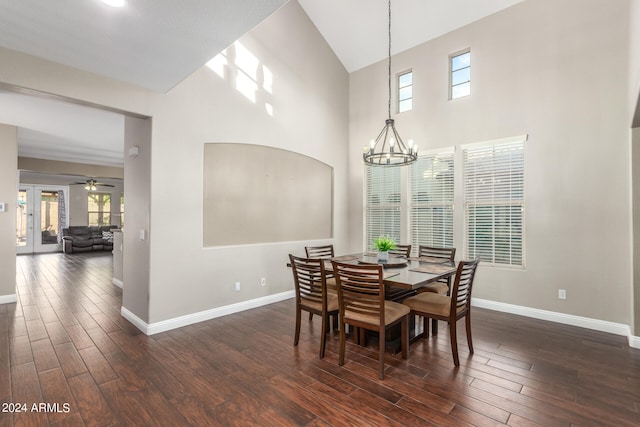 dining room with dark wood-type flooring, vaulted ceiling, and ceiling fan with notable chandelier