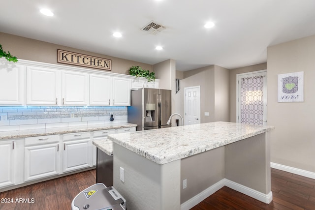 kitchen featuring stainless steel refrigerator with ice dispenser, a kitchen island with sink, white cabinets, and dark hardwood / wood-style floors