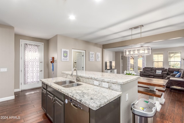 kitchen featuring pendant lighting, dishwasher, dark brown cabinets, and a center island with sink