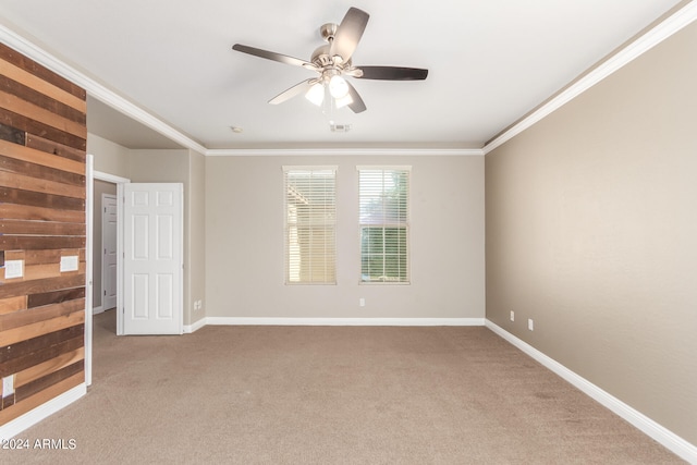 empty room with ceiling fan, ornamental molding, and light carpet