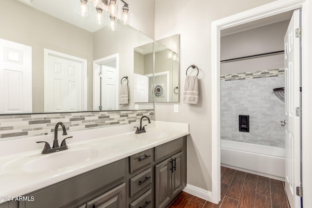 bathroom with vanity, tiled shower / bath, and decorative backsplash