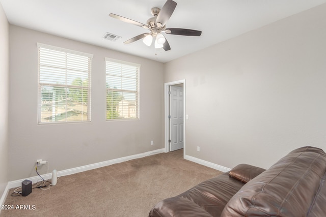 living area featuring ceiling fan and light carpet