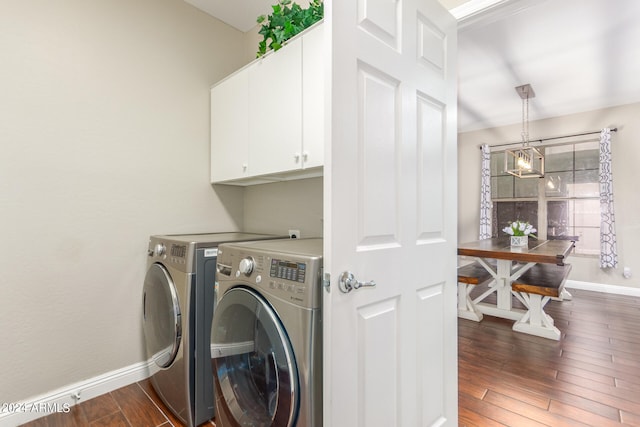 laundry room featuring cabinets, washing machine and dryer, dark wood-type flooring, and an inviting chandelier