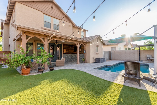 rear view of property featuring a fenced in pool, a patio, french doors, and a lawn