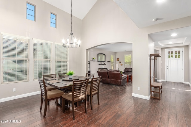 dining room featuring dark hardwood / wood-style flooring, a chandelier, and a high ceiling