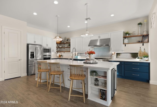 kitchen featuring appliances with stainless steel finishes, white cabinetry, hanging light fixtures, a center island with sink, and blue cabinets