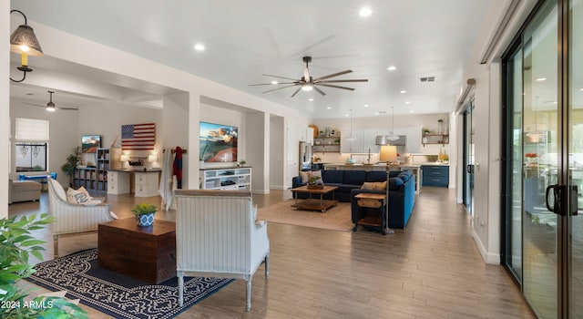 living room featuring ceiling fan and light hardwood / wood-style flooring