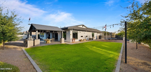 rear view of house featuring a trampoline, central air condition unit, and a lawn