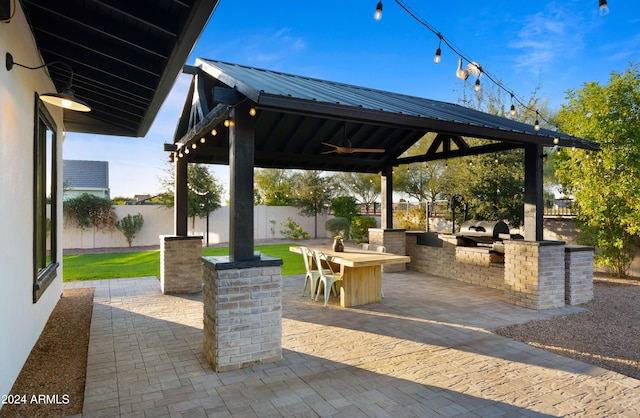 view of patio with ceiling fan, an outdoor kitchen, a gazebo, and exterior bar