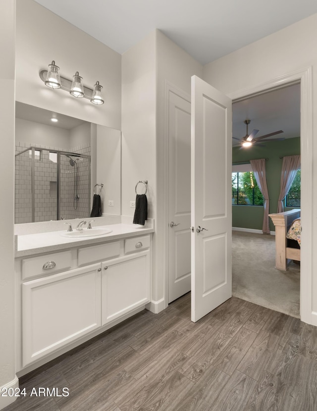 bathroom featuring vanity, ceiling fan, wood-type flooring, and an enclosed shower