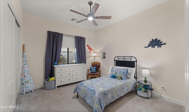 bedroom featuring ceiling fan, a closet, and light colored carpet