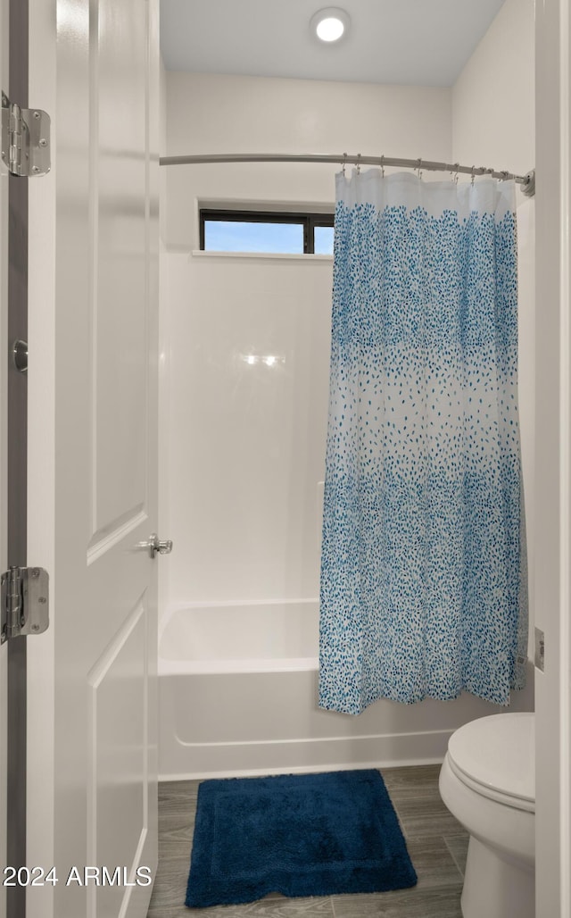 bathroom featuring toilet, shower / bath combination with curtain, and hardwood / wood-style floors