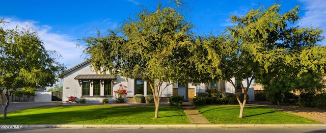 view of property hidden behind natural elements with a front yard