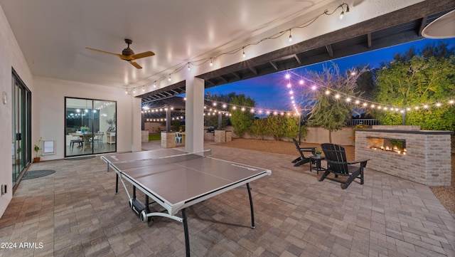 view of patio / terrace with ceiling fan and an outdoor fireplace