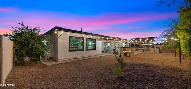 back house at dusk with a patio area and area for grilling