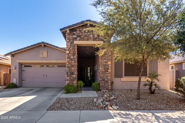 view of front of property featuring a garage, concrete driveway, stone siding, a tiled roof, and stucco siding