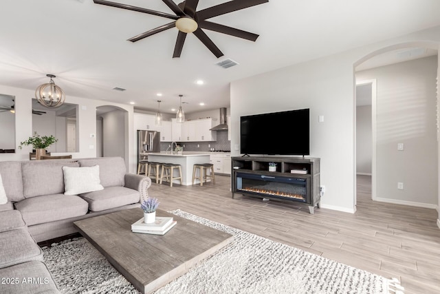 3474 W Dreamy Draw Dr, Queen Creek, AZ 85144 - living room featuring a ceiling fan, arched walkways, recessed lighting, light wood-type flooring, and baseboards