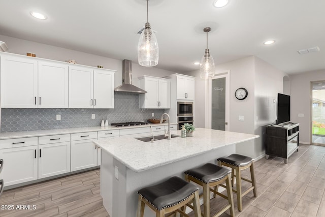 3474 W Dreamy Draw Dr, Queen Creek, AZ 85144 - kitchen featuring wall chimney exhaust hood, a sink, appliances with stainless steel finishes, wood tiled floors, and backsplash