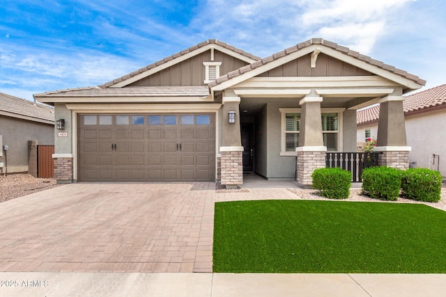 3474 W Dreamy Draw Dr, Queen Creek, AZ 85144 - craftsman house with decorative driveway, a tiled roof, a garage, stone siding, and covered porch