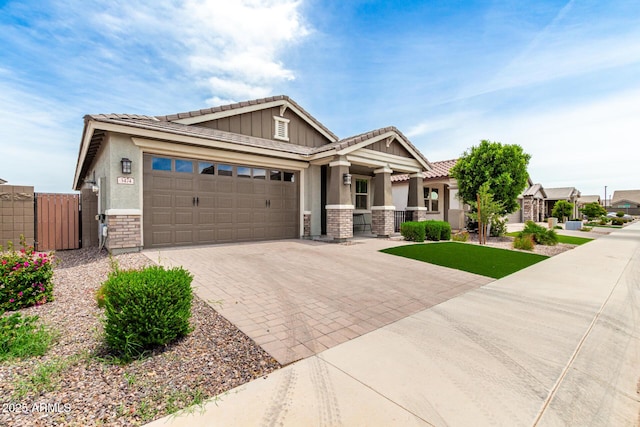 3474 W Dreamy Draw Dr, Queen Creek, AZ 85144 - craftsman-style home with a gate, a tile roof, stone siding, decorative driveway, and a garage