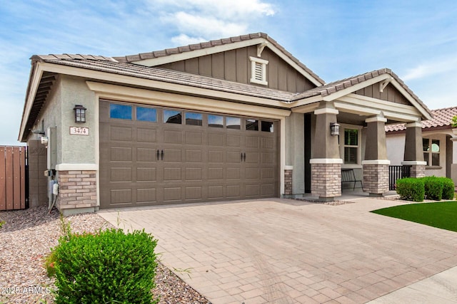 3474 W Dreamy Draw Dr, Queen Creek, AZ 85144 - craftsman-style house featuring a tile roof, a garage, decorative driveway, a porch, and stucco siding