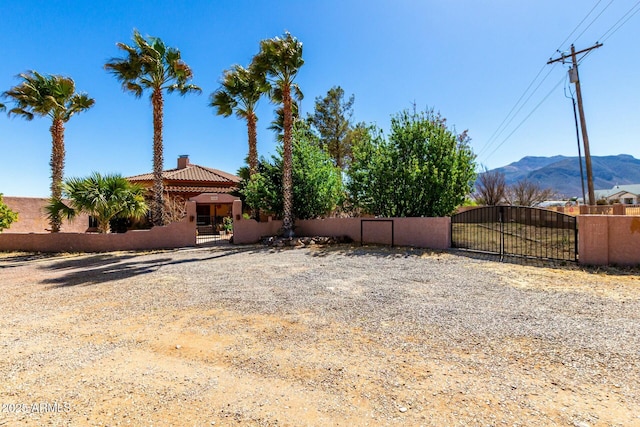 view of yard with a gate, fence, and a mountain view