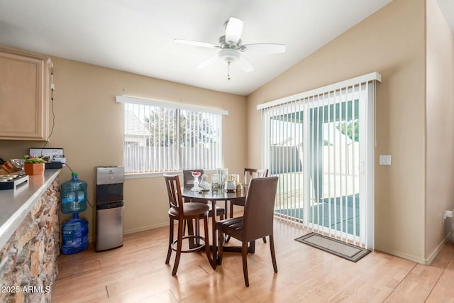 dining area featuring lofted ceiling, baseboards, ceiling fan, and light wood finished floors