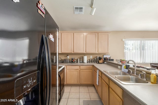 kitchen featuring light countertops, black refrigerator with ice dispenser, a sink, and light tile patterned flooring