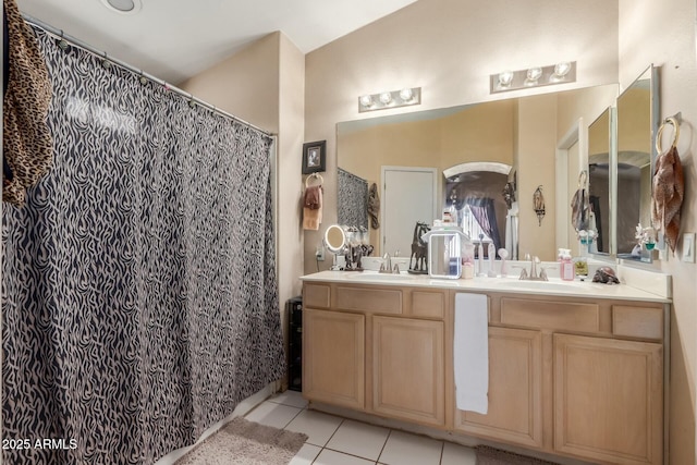 full bath featuring double vanity, a shower with shower curtain, a sink, and tile patterned floors