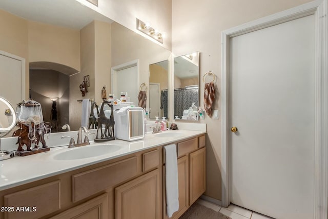 bathroom featuring double vanity, a sink, a shower stall, and tile patterned floors