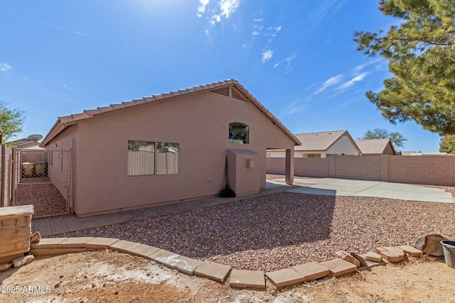 rear view of property featuring a patio area, a fenced backyard, and stucco siding