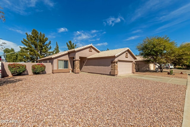 view of front of house with an attached garage, fence, a tile roof, concrete driveway, and stucco siding