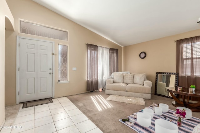 living area featuring lofted ceiling, light tile patterned floors, and light carpet