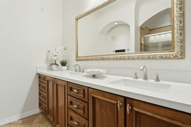 full bathroom featuring double vanity, a sink, an enclosed shower, and tile patterned flooring