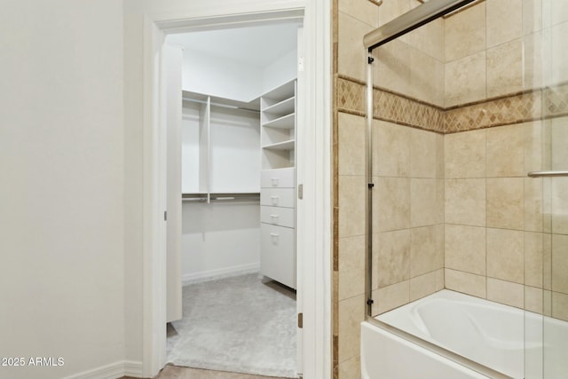full bath featuring combined bath / shower with glass door and a walk in closet