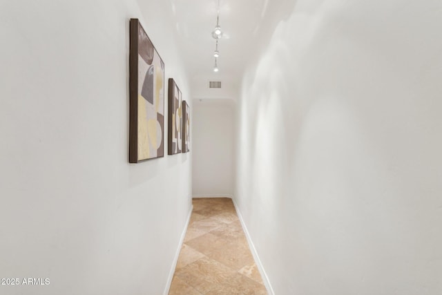corridor featuring baseboards and visible vents