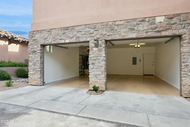 garage featuring concrete driveway, a garage door opener, and electric panel