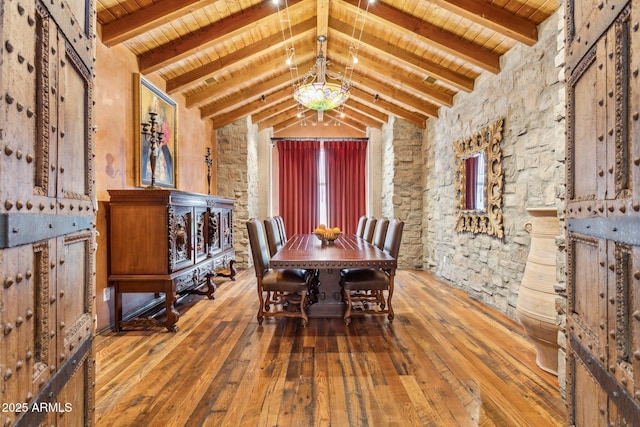 dining area with vaulted ceiling with beams, wood ceiling, a notable chandelier, and hardwood / wood-style flooring