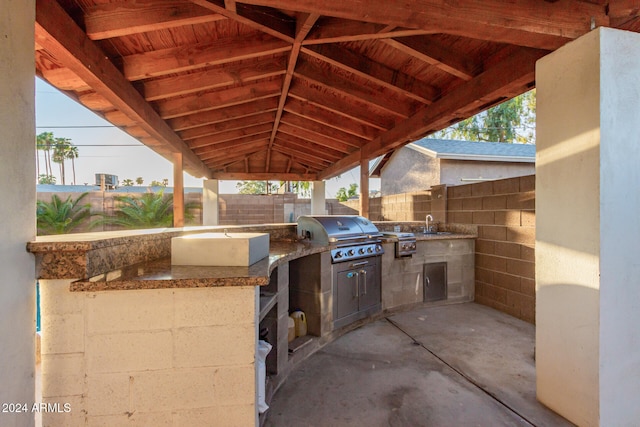 view of patio with area for grilling, sink, and exterior kitchen