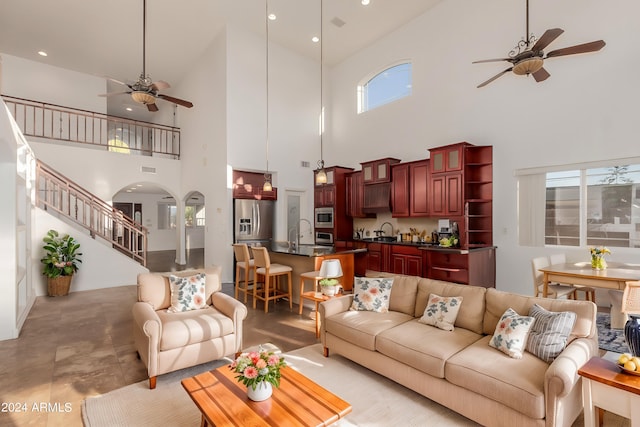 living room with high vaulted ceiling, sink, and a wealth of natural light