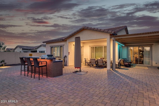 view of patio / terrace featuring outdoor dry bar and fence