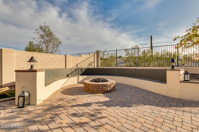 view of patio with fence and a fire pit