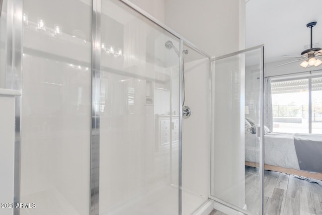 bathroom featuring wood finished floors, ceiling fan, a shower stall, and ensuite bathroom